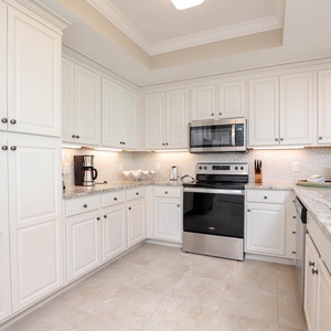 Prepare meals in this kitchen with elegant cabinetry, stainless appliances, and stylish backsplash