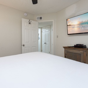 Master bedroom featuring a large king bed, a mounted TV, and warm lighting for a relaxing retreat