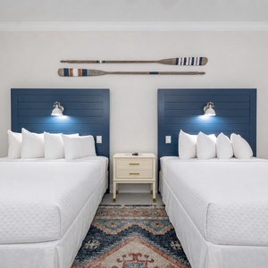 Inviting guest room featuring two comfortable queen beds, stylish decor, and innovative lighting