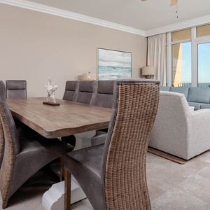 Gather around the stylish dining table, where laughter and conversation flow amid coastal breezes and light