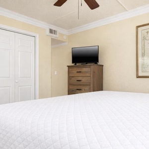 This guest suite features a cozy king bed, a stylish dresser, and a TV for relaxation