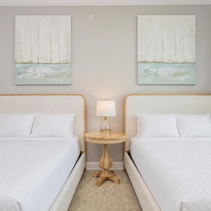 Peaceful guest retreat in this dual queen room with fluffy pillows and coastal vibe