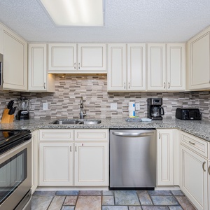 Light cabinetry, granite countertops, and a stylish backsplash complete this kitchen, creating a welcoming cooking space