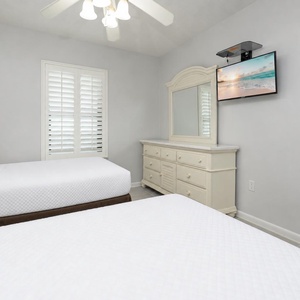 Sleep peacefully in this inviting guest room with two cozy double beds, a dresser, and a TV for your entertainment