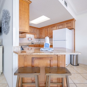 Wood cabinetry and granite countertops complement the breakfast bar and open design in this kitchen