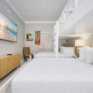 Rest comfortably in this inviting guest room with two queens with two loft twins above and vibrant artwork