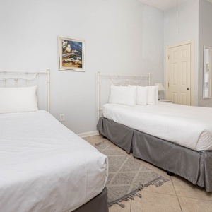 Guest bedroom featuring a twin bed and a full bed and a twin bunk bed, complemented by soft linens and charming wall art