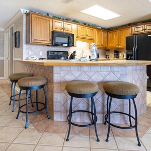 Gather around the spacious breakfast bar with comfortable seating, perfect for coffee and conversations