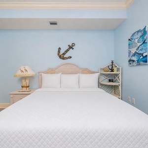 Sink into the soft queen bedding of this tranquil guest bedroom, where beach-themed decor invites restful relaxation