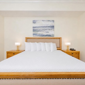 Relaxing master bedroom featuring a king bed, stylish lamps, and soothing artwork above the headboard