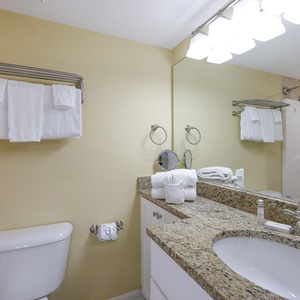Guest bathroom featuring a granite countertop, fresh towels, and a tub/shower combo for a refreshing experience