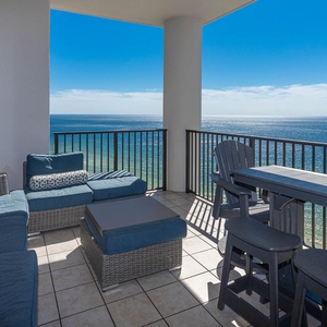 This balcony features modern outdoor furniture and seating arrangements with beach views from the sixteenth floor