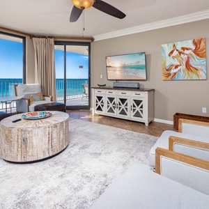 Relax in the airy living area featuring a sofa with queen sleeper, large TV, and stunning beach views