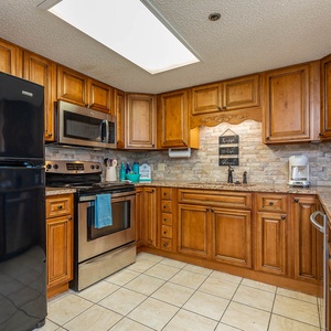 Cook and gather in the inviting kitchen, featuring rich wood cabinets, granite countertops, and stainless appliances