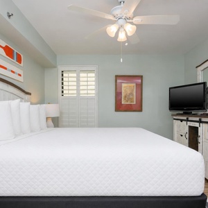 Guest bedroom featuring a plush king bed, stylish decor, and a flat-screen TV for entertainment
