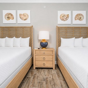 Inviting guest room featuring two queen beds, soft lighting, and relaxing vibe for a restful stay
