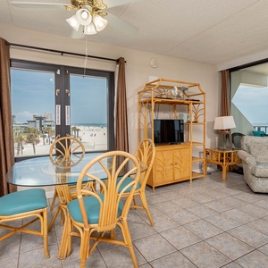 The living and dining areas feature a glass dining table and offers stunning beachfront views through large windows
