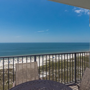 Balcony view showcasing the tranquil gulf waters and white sand beach, perfect for relaxing under a sunny sky