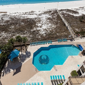 Take a refreshing dip in the inviting pool surrounded by lounge chairs and lush landscaping for a relaxing day outdoors