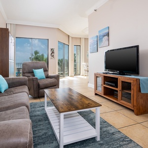 Spacious living area featuring a queen sofa sleeper and full murphy bed, large TV, and beachfront views