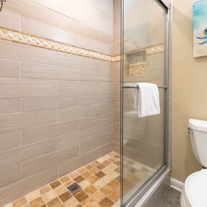The master bathroom features a walk-in shower with glass doors, stylish tile accents, and a clean, modern aesthetic