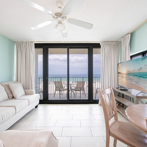 Relax in the inviting living area with a view of the beach, featuring a sofa with queen sleeper and TV