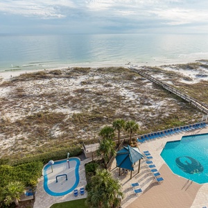 Enjoy the inviting pool area surrounded by palm trees and lounge chairs, perfect for relaxation and fun