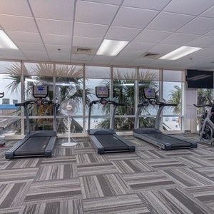 Stay active in the fitness center at Seawind with stunning beach views, featuring treadmills and exercise bikes
