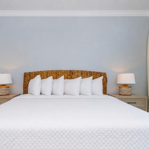 Serene guest bedroom featuring a king bed, stylish lamps, and large windows showcasing beautiful views