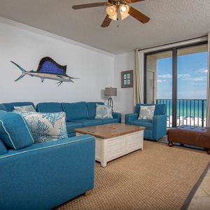 Relax in the vibrant living area featuring a sofa with queen sleeper, coastal decor, and views of the beach