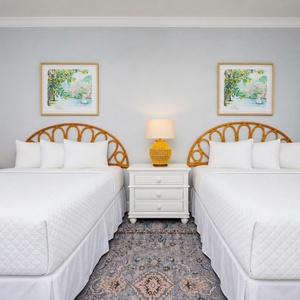 Inviting queen guest bedroom featuring two cozy beds, soft linens, and charming coastal artwork