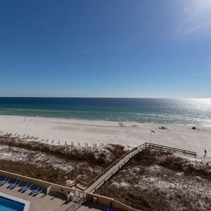 Expansive beachfront view showcasing white sand, gentle waves, and a serene atmosphere, perfect for relaxation and enjoyment