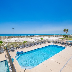 Lounge by the glistening pool, soaking in the inviting vibe and beautiful views of the tranquil beach