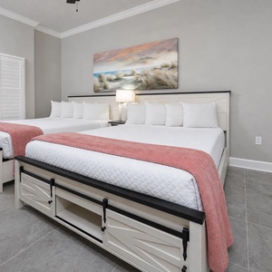 Unwind among fluffy pillows in this queen guest suite, read by the lamp, and admire the beach print above the beds