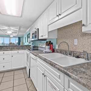 Cheerful kitchen featuring modern appliances, stylish countertops, and a lovely view of the beach outside