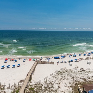 Serene beach dotted with colorful umbrellas and lounge chairs, inviting relaxation and fun in the sun