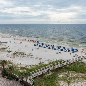 Enjoy views of the beach and pool area with colorful umbrellas and lounge chairs, perfect for relaxation and fun in the sun