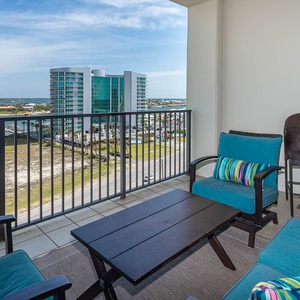 Relax on the balcony with comfortable seating and a table, enjoying views of the water and surrounding landscape