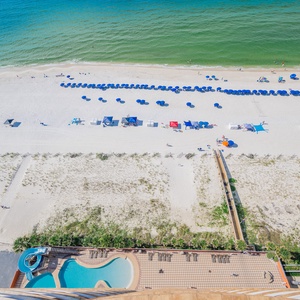 Vibrant beach scene with colorful umbrellas, sunbathers, and the refreshing gradual entry pool area