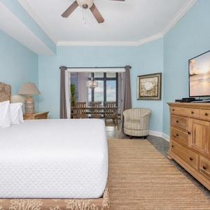 Inviting master bedroom featuring a plush king bed, a cozy chair, and a stunning view through sliding glass doors