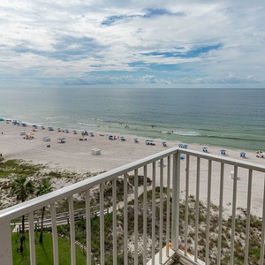 This inviting balcony offers a stunning beachfront view, perfect for relaxing with a drink while enjoying the sea breeze