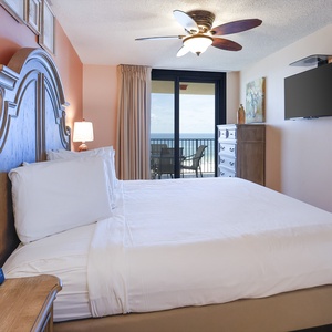 Brightly colored walls complement the cozy king bed and provide a view of the balcony, enhancing the relaxing atmosphere