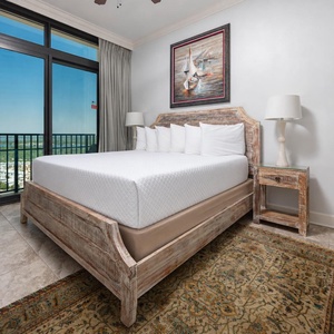 This bedroom features a stylish wooden king bed and offers stunning views through large windows, enhancing your stay
