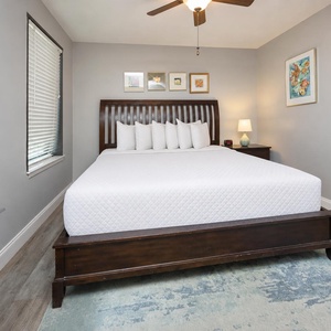The serene guest bedroom features a king bed with plush pillows, a stylish nightstand, and lighting for a restful ambiance