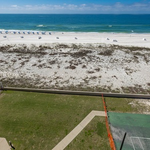 Enjoy the spacious outdoor pool area with seating and a view of the beach, perfect for relaxation and gatherings