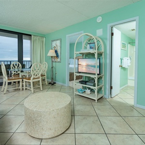 Living area featuring a cozy seating arrangement, queen sofa-sleeper, and a dining table with a beautiful coastal view
