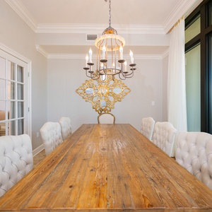 Gather around the long dining table to share laughter and create cherished memories while enjoying the coastal view