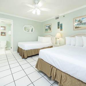 Relax in this guest room featuring two double beds, soft linens, and charming coastal decor