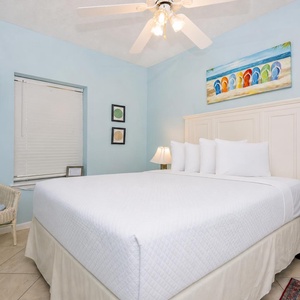 Brightly colored decor complements the cozy queen bed in the guest bedroom, with a TV enhancing the inviting atmosphere