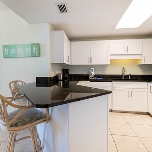 Prepare meals at the sleek black countertop, with easy access to the inviting kitchen and nearby dining area